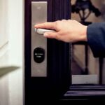 Hand opening a door fitted with a digital smart lock access panel