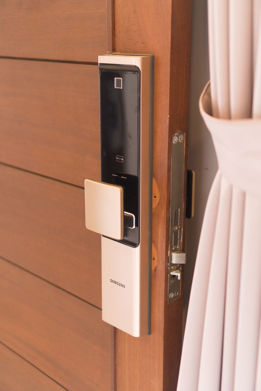 Close-up of a smart door lock keypad installed on a wooden front door