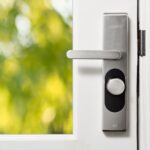 White front door with a modern smart lock keypad, similar in style to the DESLOC V150 Plus solar smart lock