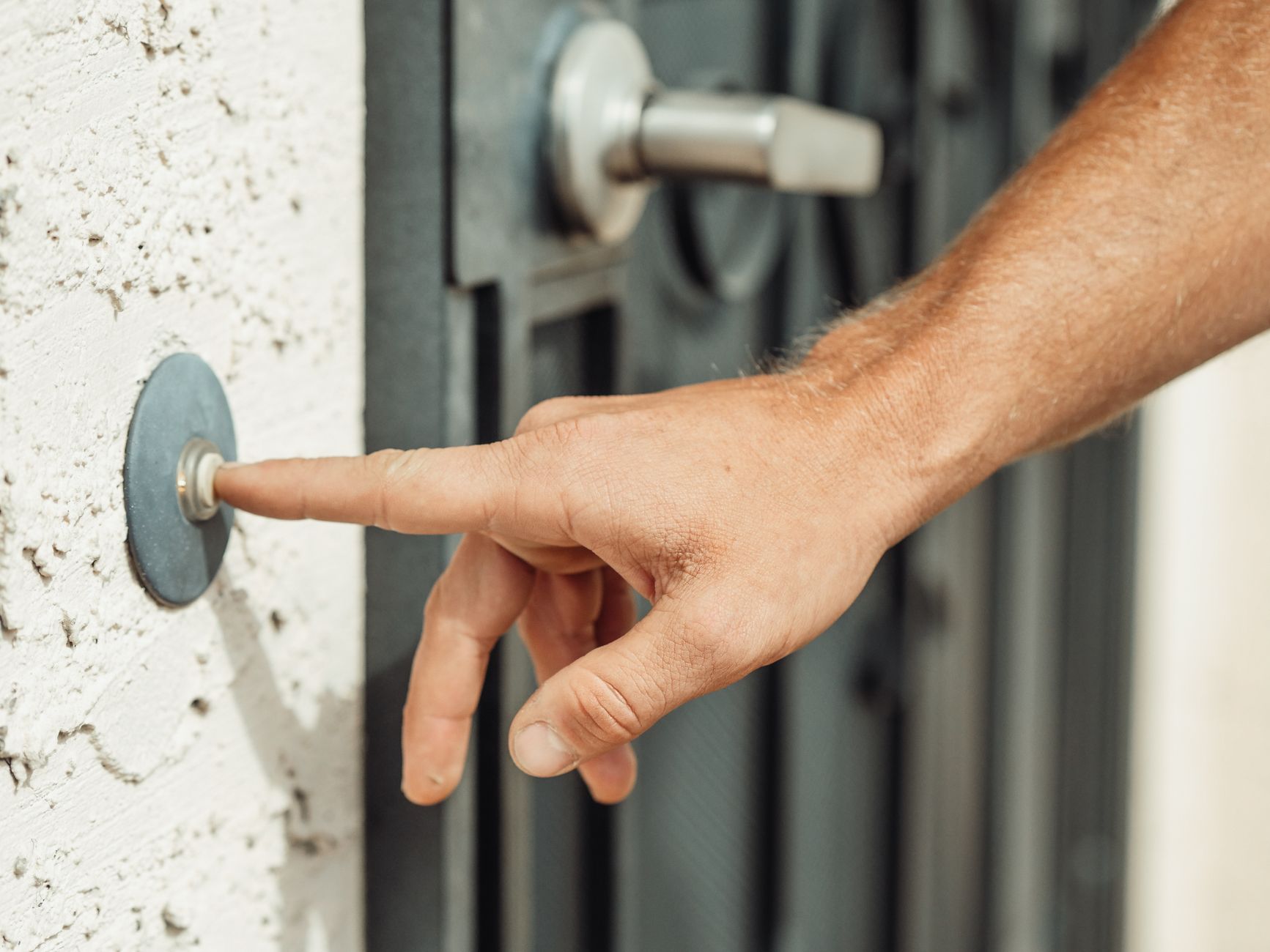 Person using a smart home video doorbell app on a phone at a front door